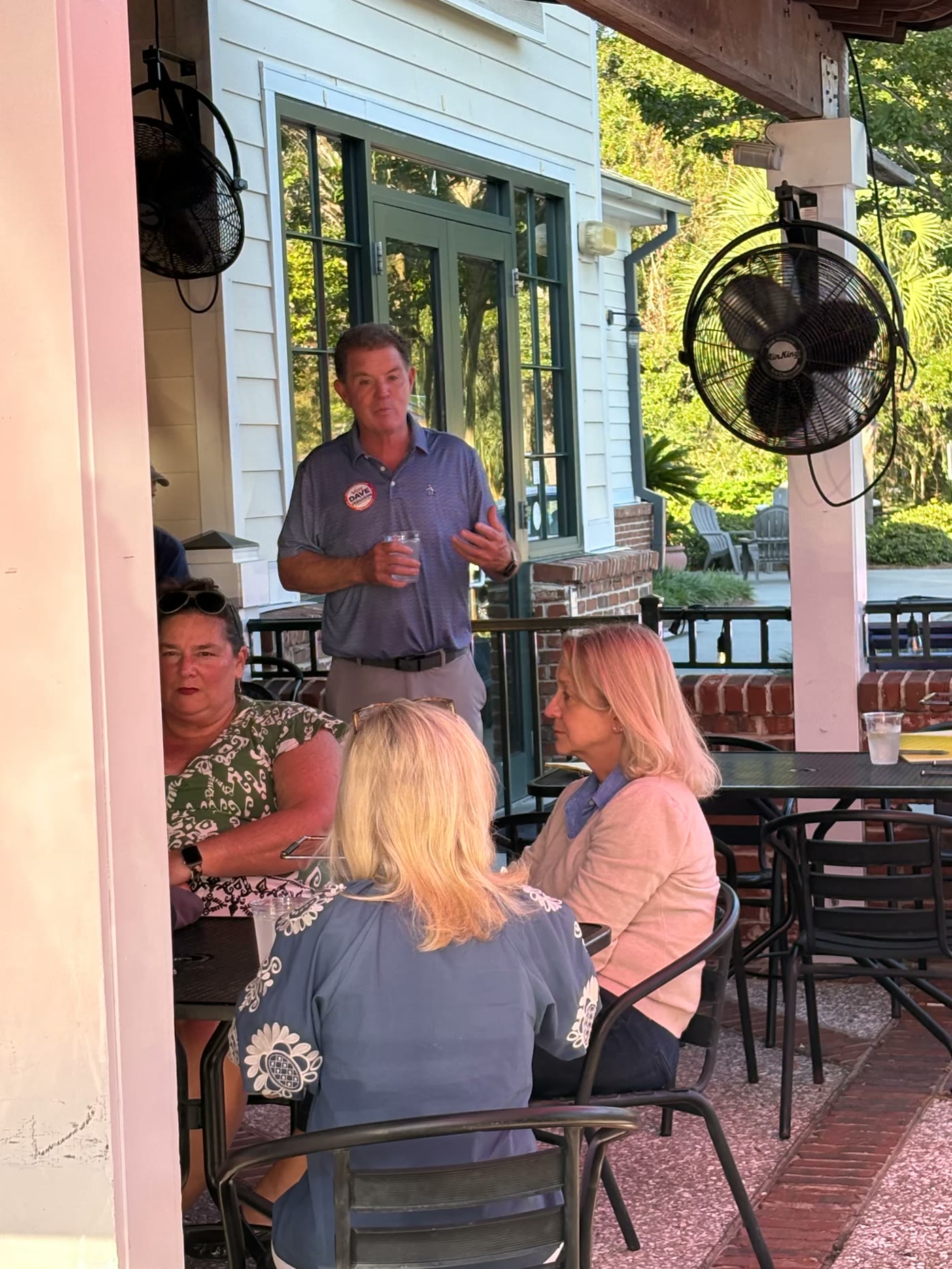 Dave Ferguson speaking with residents on a restaurant patio